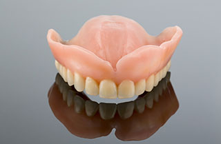 How Can Dental Implants Be Used to Improve My Full or Partial Dentures?